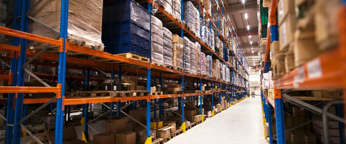 interior-large-distribution-warehouse-with-shelves-stacked-with-palettes-goods-ready-market-1.webp